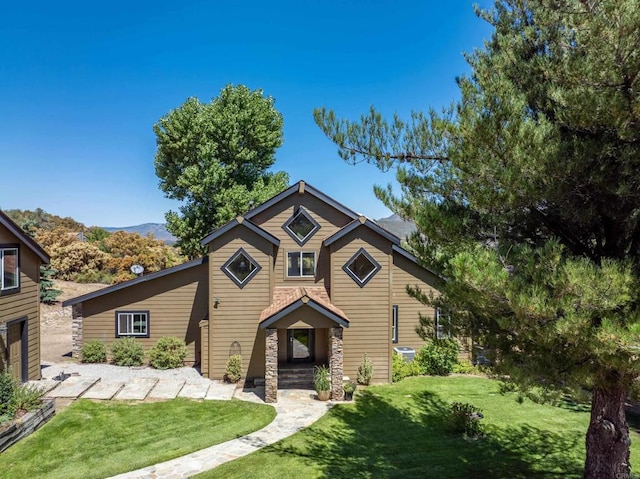 view of front of property with a front lawn and a mountain view