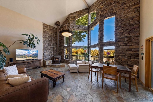 living room with a wood stove and high vaulted ceiling