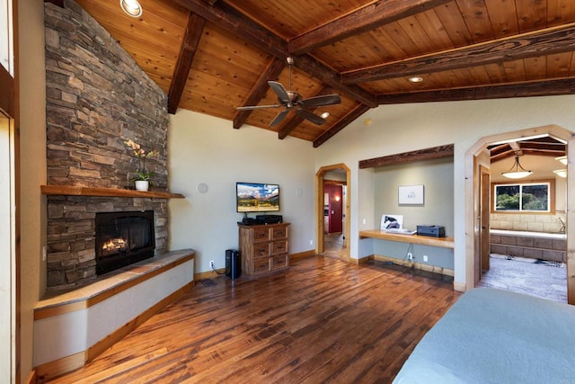 bedroom with wooden ceiling, vaulted ceiling with beams, a stone fireplace, and wood-type flooring