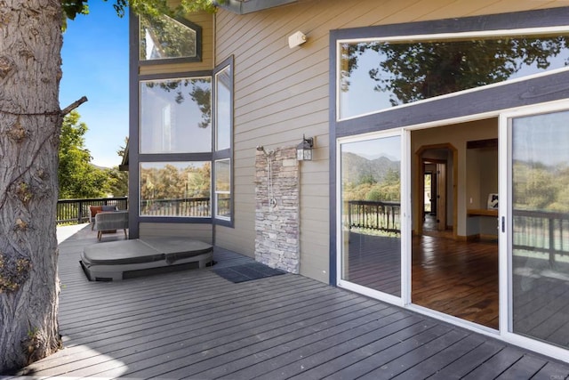 wooden terrace with a covered hot tub