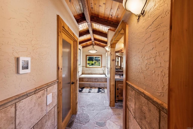 hallway featuring wooden ceiling and lofted ceiling with beams