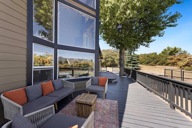 wooden deck with a mountain view and an outdoor living space