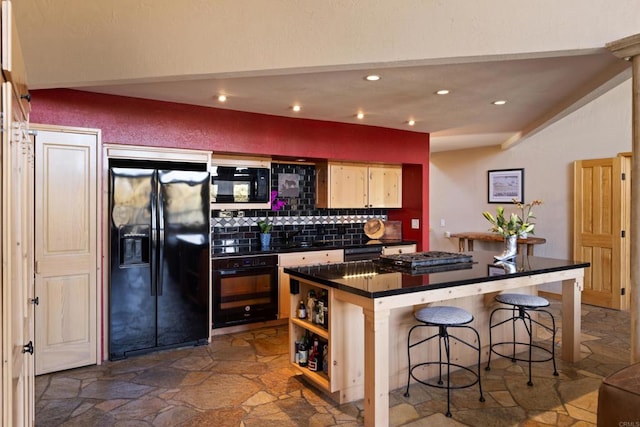 kitchen featuring a kitchen breakfast bar, black appliances, light brown cabinets, and tasteful backsplash