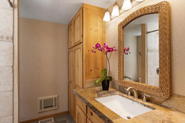 bathroom featuring a textured ceiling and vanity