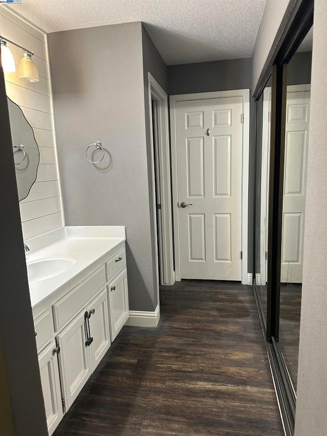 bathroom featuring a textured ceiling, vanity, and hardwood / wood-style flooring