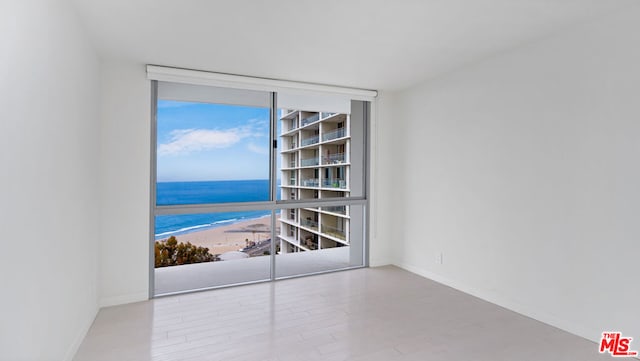 unfurnished room featuring a water view and light wood-type flooring