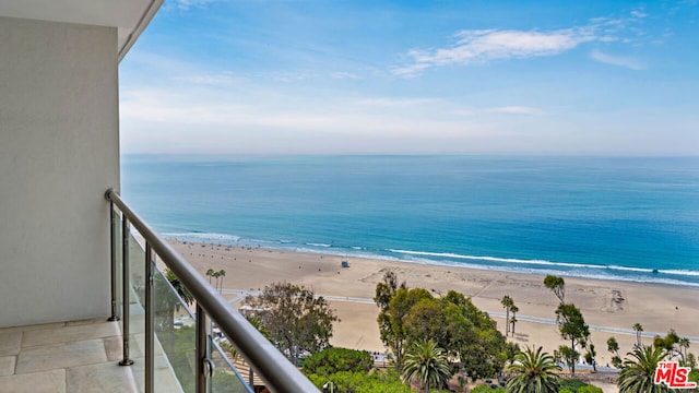 balcony featuring a water view and a beach view