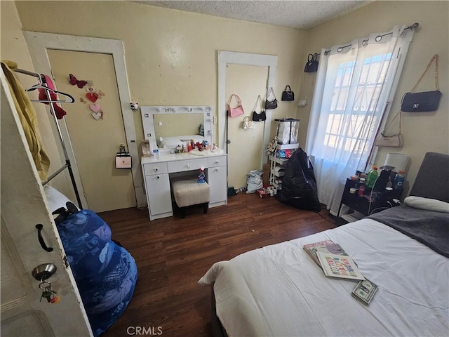 bedroom with dark hardwood / wood-style flooring and a textured ceiling