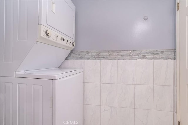 laundry room featuring stacked washer / dryer and laundry area