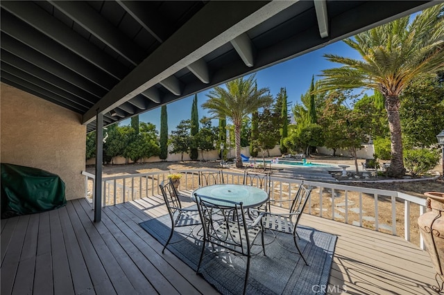 wooden terrace featuring grilling area and a swimming pool