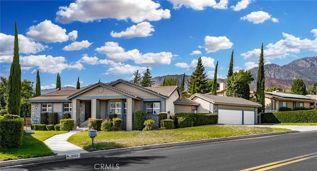 view of front of property with a mountain view, a garage, and a front lawn