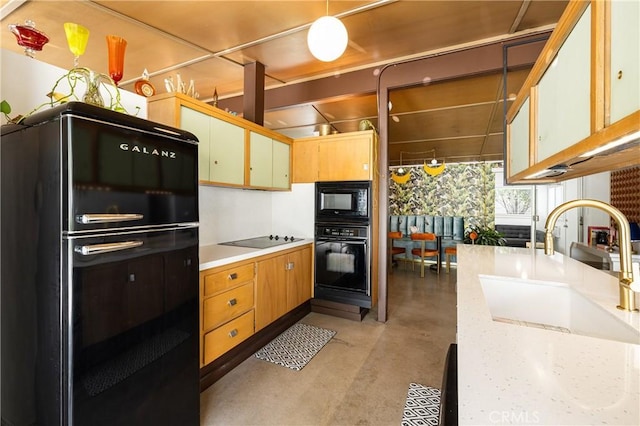 kitchen featuring decorative light fixtures, sink, and black appliances