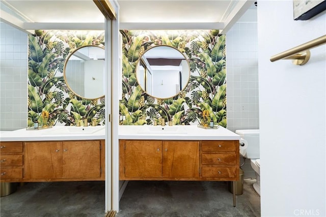 bathroom featuring vanity, toilet, tile walls, and concrete floors