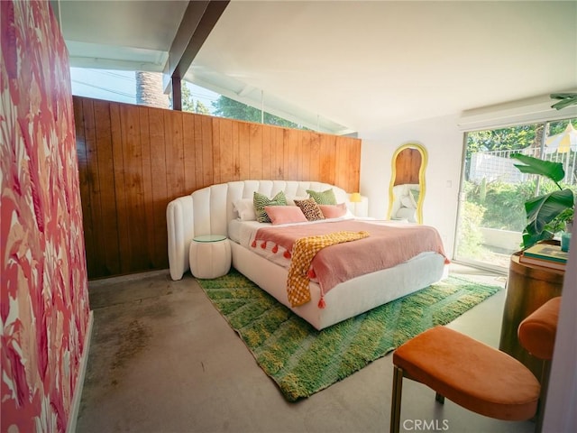 bedroom featuring vaulted ceiling with beams, access to outside, concrete floors, and wooden walls