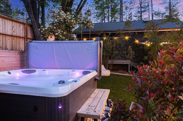 yard at dusk featuring a hot tub