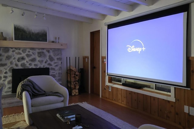 home theater room with beamed ceiling and wood-type flooring