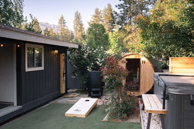 view of patio / terrace with a hot tub, a shed, and a mountain view