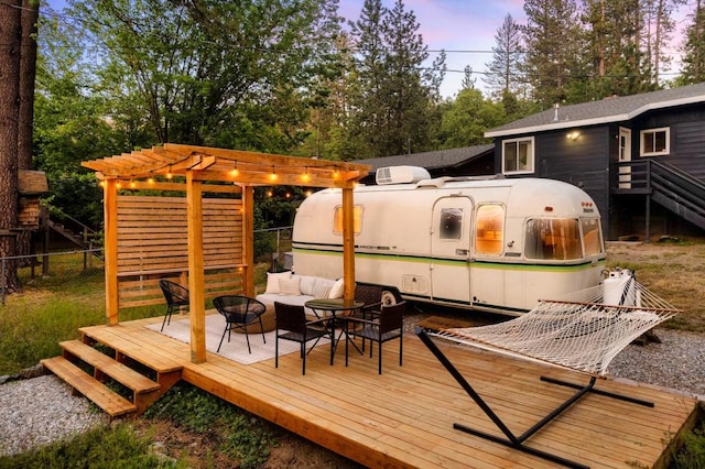 deck at dusk featuring a pergola