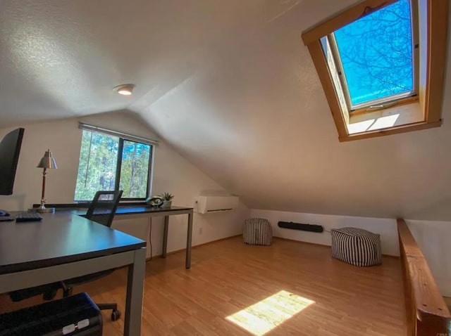 bonus room with light hardwood / wood-style floors, lofted ceiling with skylight, and a textured ceiling