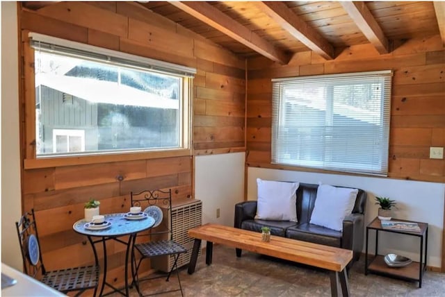 living area featuring wood ceiling, wood walls, and beamed ceiling