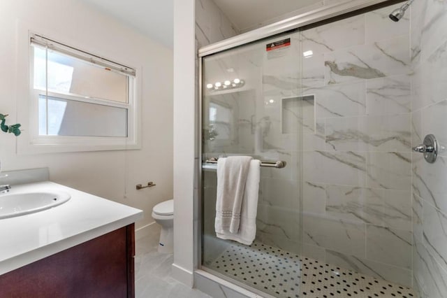 bathroom featuring vanity, toilet, and an enclosed shower