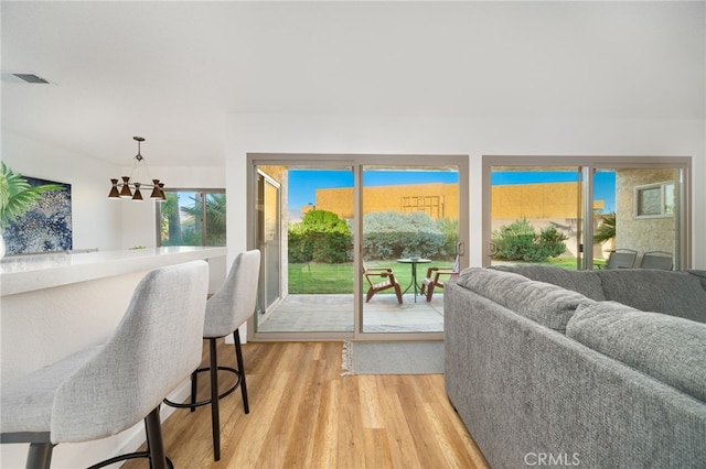 living room featuring light hardwood / wood-style floors and a notable chandelier