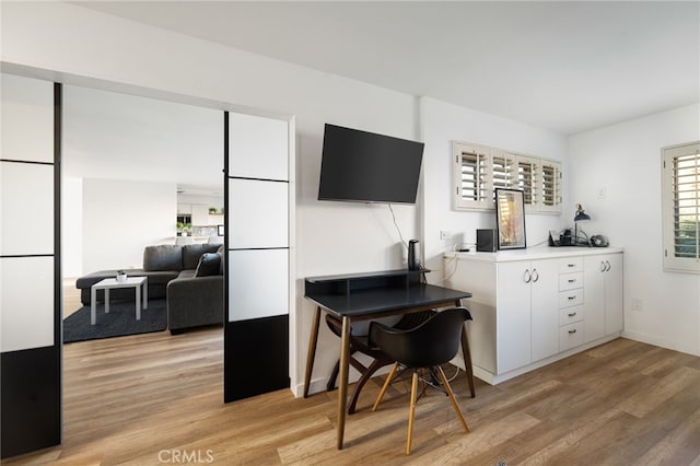 interior space featuring light wood-type flooring and white cabinets