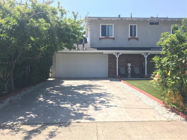 traditional-style home featuring a garage, driveway, and stucco siding