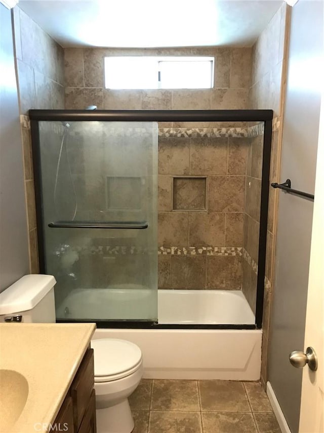 bathroom with vanity, toilet, combined bath / shower with glass door, and tile patterned flooring