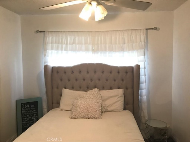 bedroom with multiple windows and ceiling fan