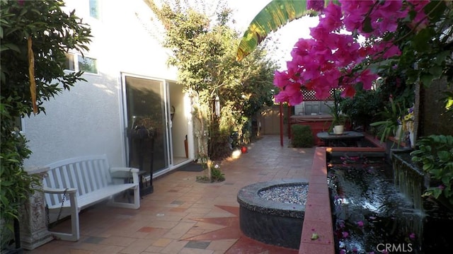 view of patio featuring fence and a hot tub