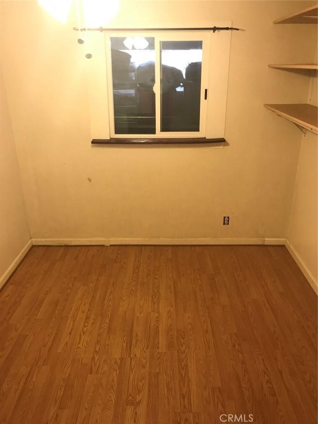 empty room featuring baseboards and wood finished floors