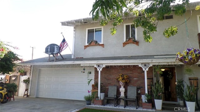 view of front facade with brick siding, a garage, driveway, and stucco siding