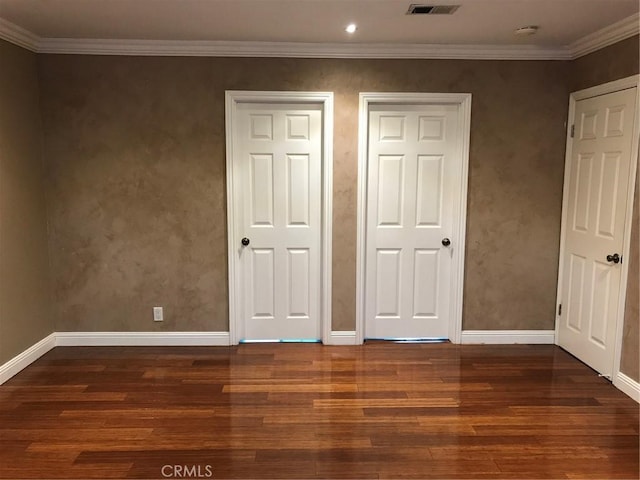 unfurnished bedroom featuring ornamental molding, baseboards, and wood finished floors