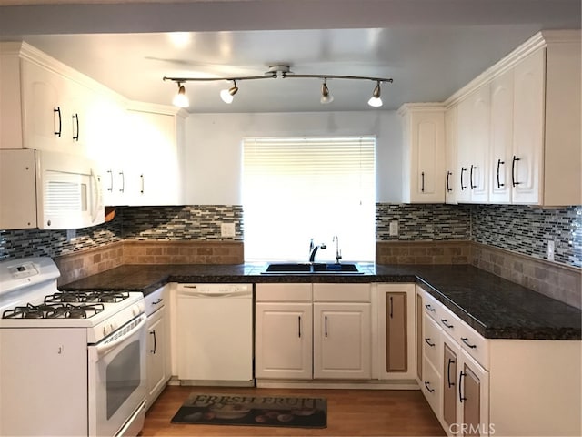 kitchen featuring white appliances, light wood finished floors, backsplash, and a sink