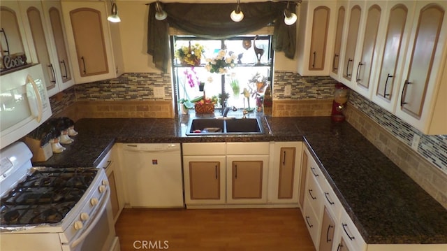 kitchen featuring decorative backsplash, tile countertops, white appliances, and a sink