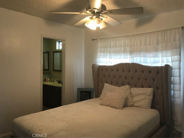 bedroom with a textured ceiling, a ceiling fan, and a sink