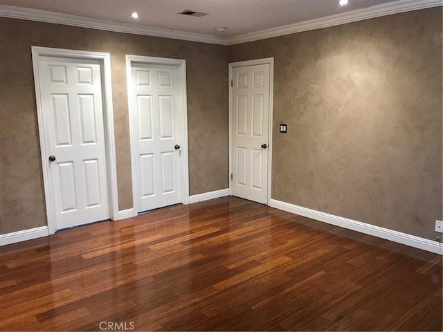 unfurnished bedroom with visible vents, wood finished floors, and crown molding