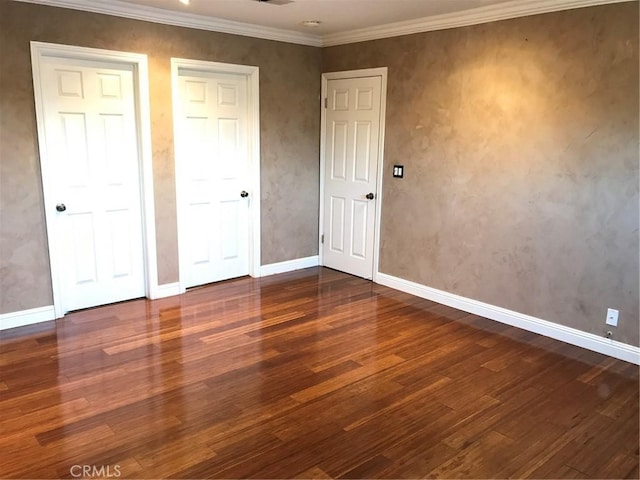 unfurnished bedroom featuring ornamental molding, baseboards, and wood finished floors