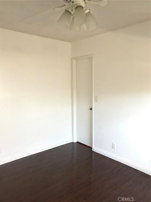 unfurnished room featuring baseboards, a ceiling fan, and dark wood-style flooring