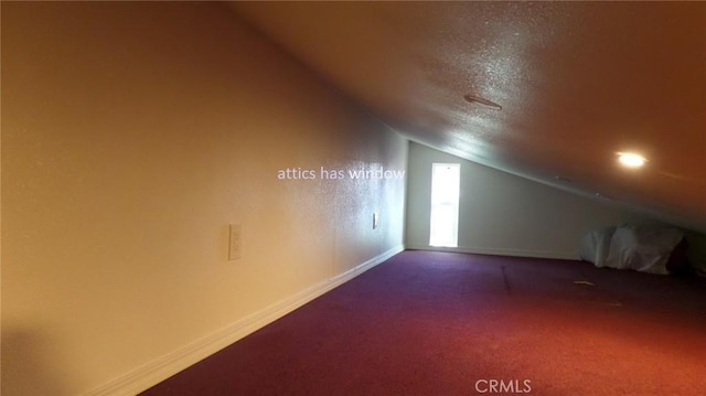 additional living space with baseboards, lofted ceiling, a textured ceiling, and carpet flooring