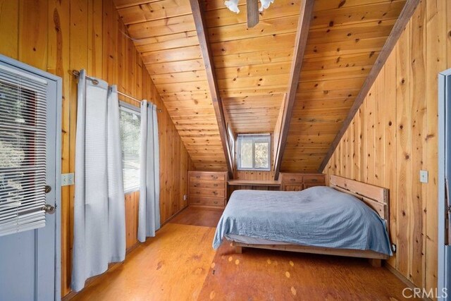 unfurnished bedroom featuring light hardwood / wood-style flooring, wood ceiling, lofted ceiling with skylight, and wooden walls