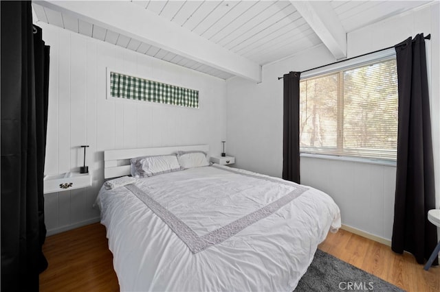 bedroom featuring wood ceiling, wooden walls, beam ceiling, and hardwood / wood-style flooring