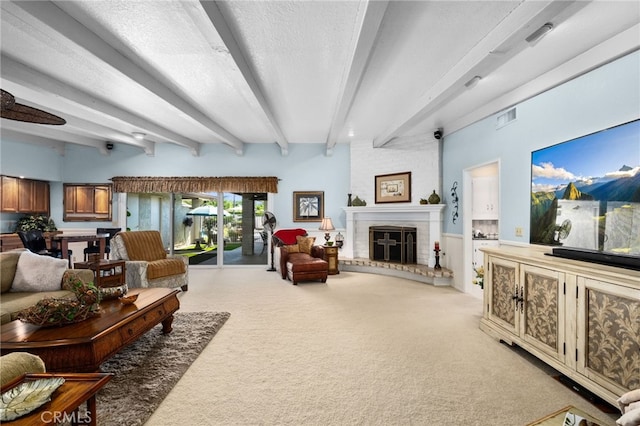 living room featuring a textured ceiling, carpet, a fireplace, and beam ceiling