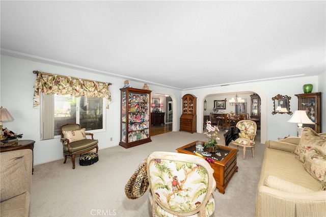 carpeted living room with crown molding and a notable chandelier