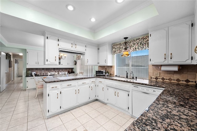 kitchen with dark stone counters, white cabinets, kitchen peninsula, decorative light fixtures, and white dishwasher