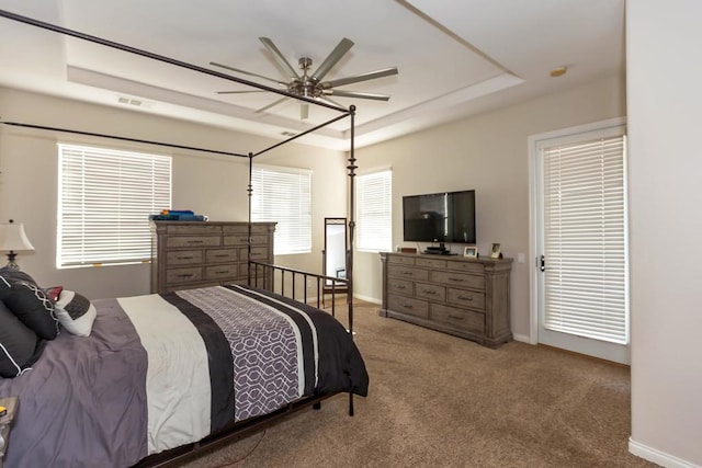 bedroom featuring ceiling fan, a raised ceiling, and carpet floors