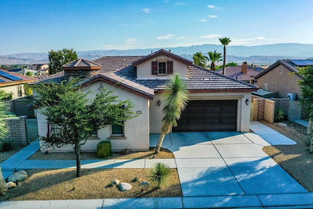 view of front of home with a mountain view and a garage