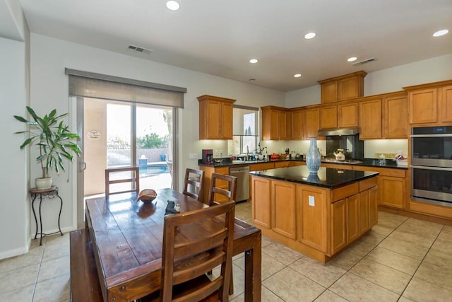 kitchen featuring a center island, light tile patterned floors, and stainless steel appliances