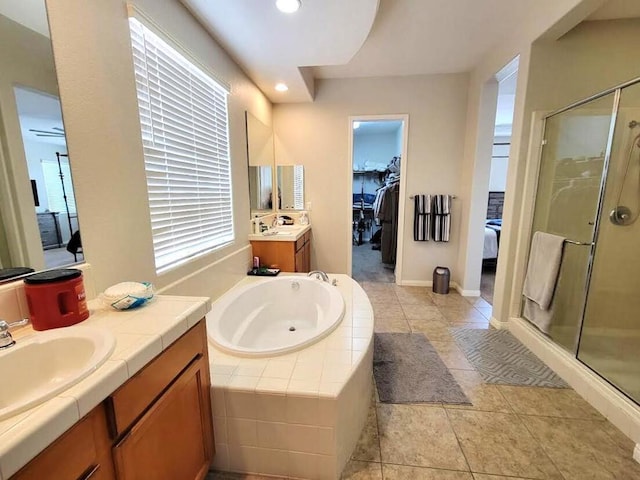 bathroom featuring tile patterned flooring, shower with separate bathtub, and vanity